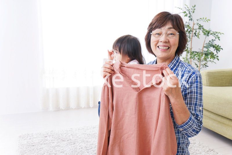 洗濯物をたたむおばあさんと子ども