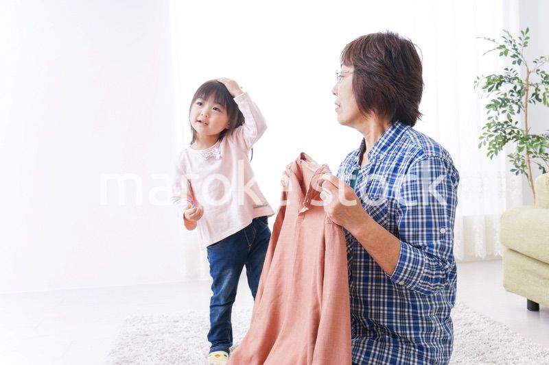 洗濯物をたたむおばあさんと子ども