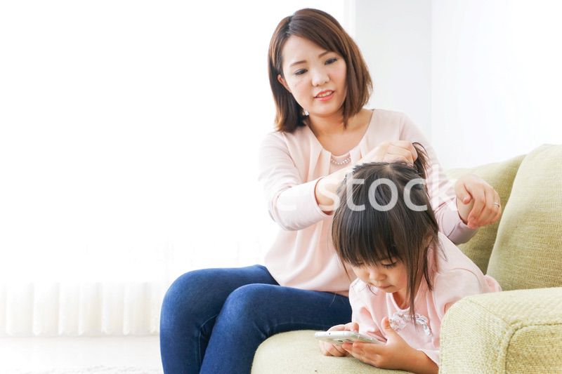 子どもの身だしなみを整える母