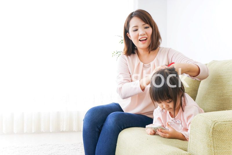 子どもの身だしなみを整える母