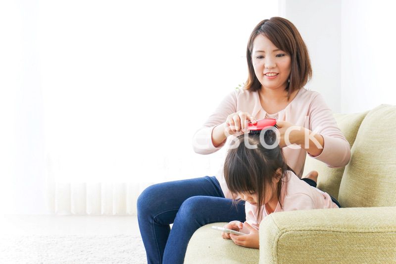 子どもの身だしなみを整える母