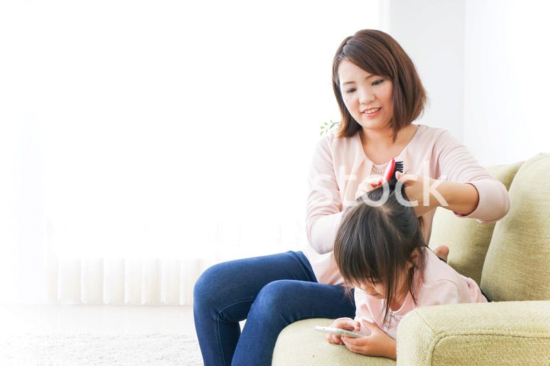 子どもの身だしなみを整える母
