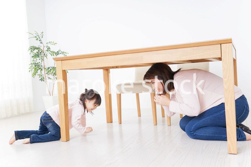 机の下に避難する親子