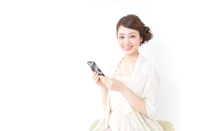 スマホを使うおしゃれ着の女性