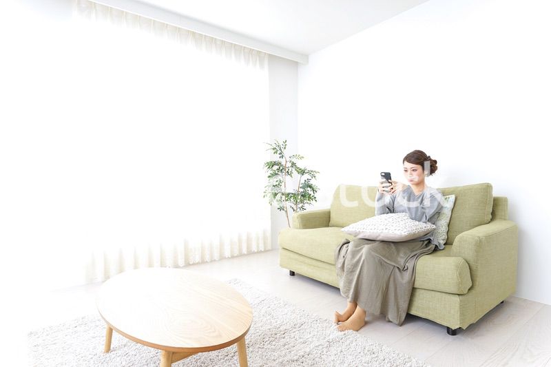 寝転んでスマホを使う女性