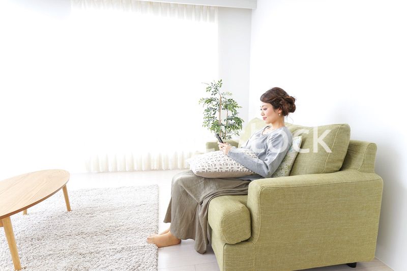 寝転んでスマホを使う女性