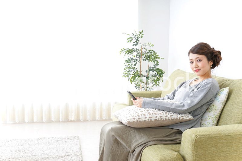 寝転んでスマホを使う女性