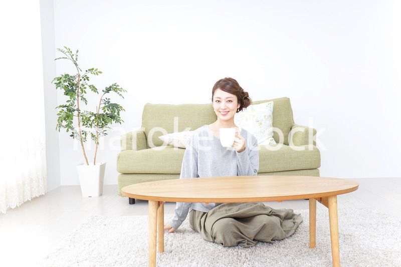 家でコーヒーを飲みくつろぐ女性