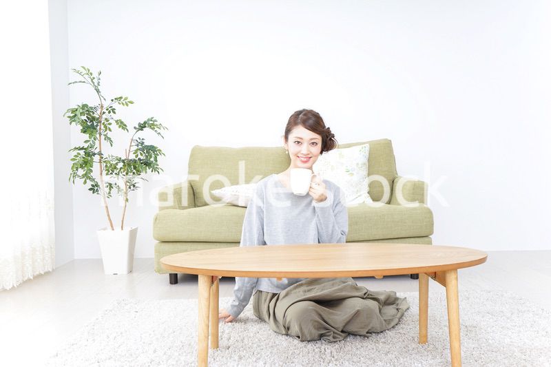 家でコーヒーを飲みくつろぐ女性