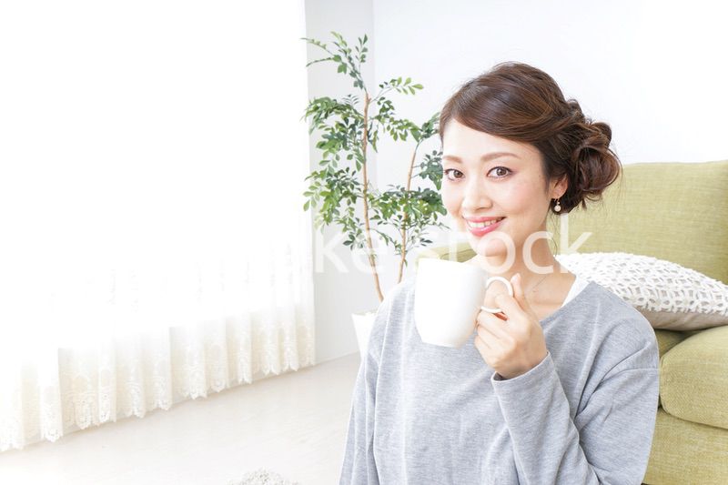 家でコーヒーを飲みくつろぐ女性