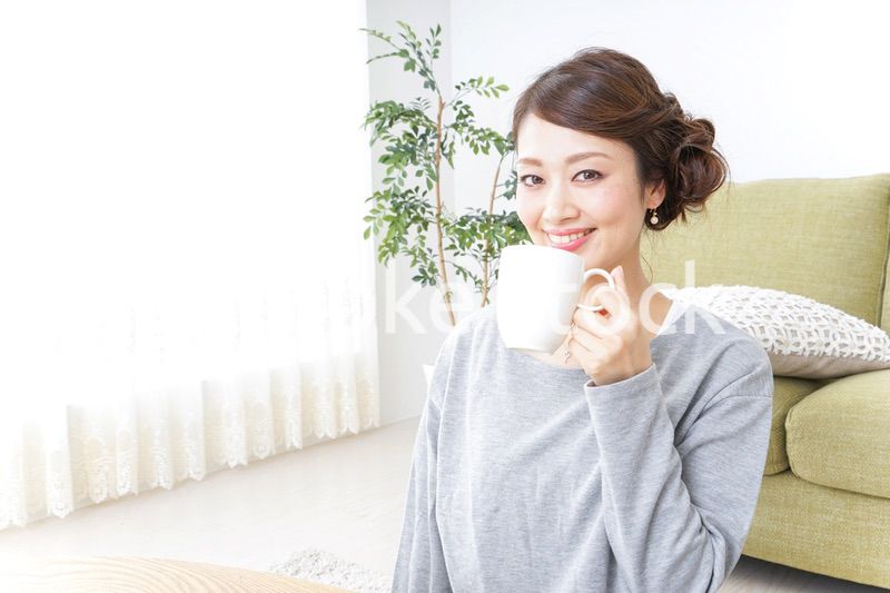 家でコーヒーを飲みくつろぐ女性