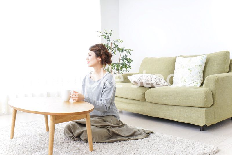 家でコーヒーを飲みくつろぐ女性