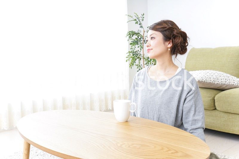 家でコーヒーを飲みくつろぐ女性