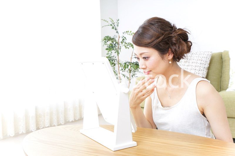 自宅でお化粧をする女性