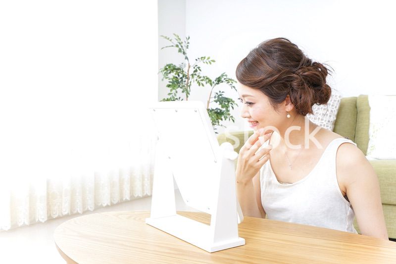 自宅でお化粧をする女性