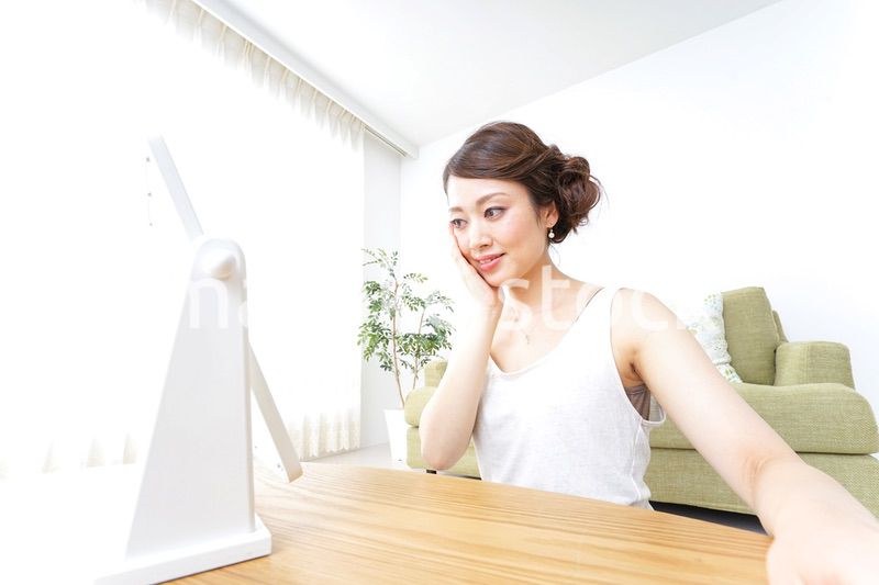 自宅でお化粧をする女性