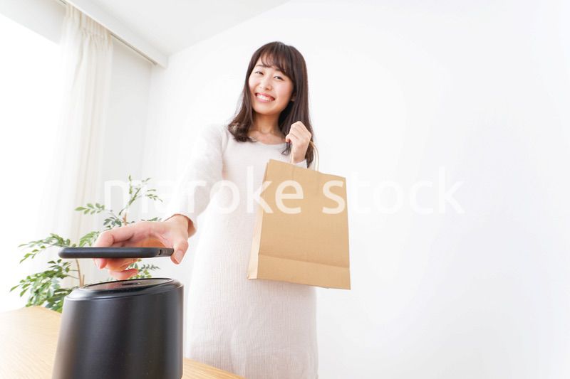 電子マネーで決済をする若い女性