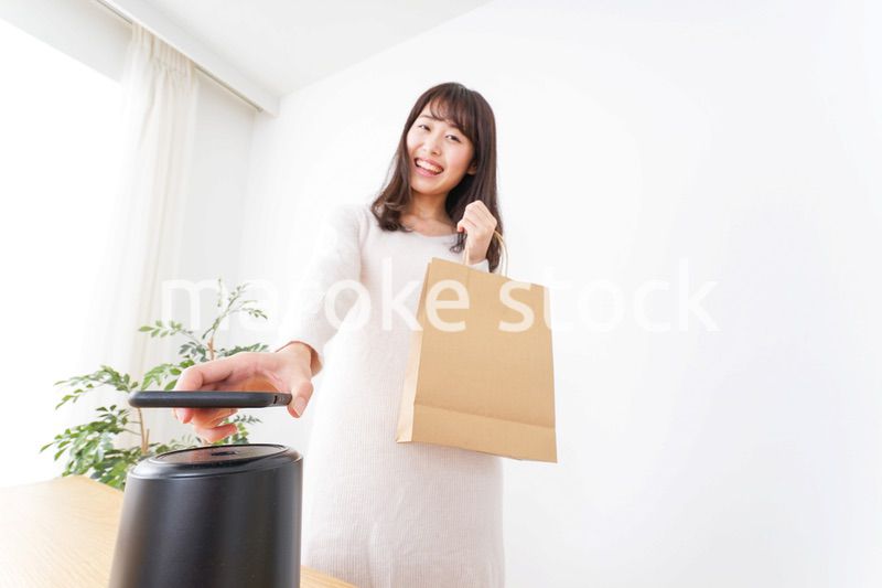 電子マネーで決済をする若い女性