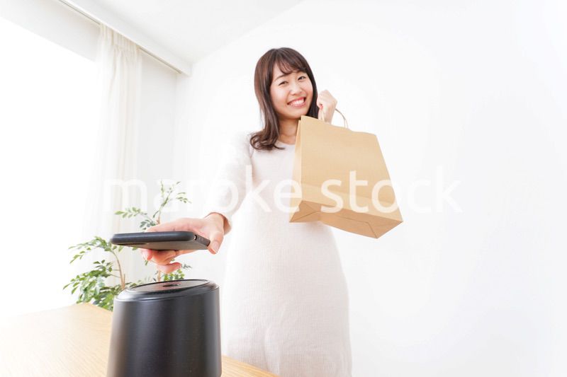 電子マネーで決済をする若い女性