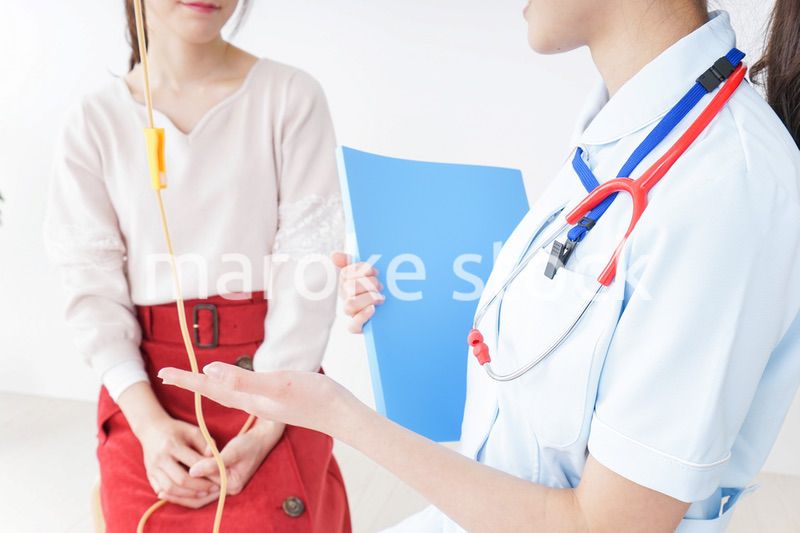 病院で診察を受ける患者とナース