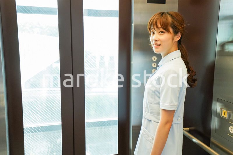 エレベーターに乗る看護師