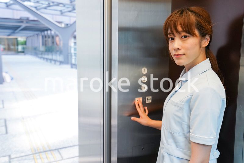 エレベーターに乗る看護師