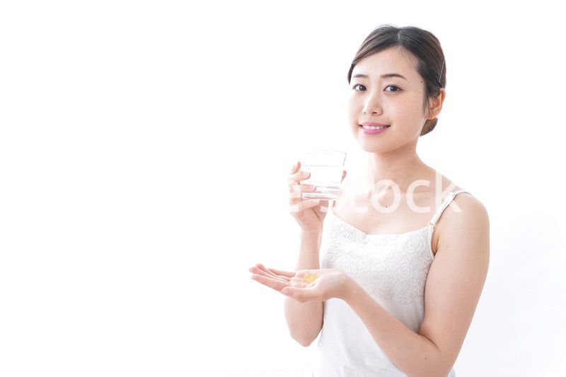 サプリメント・薬を飲む女性