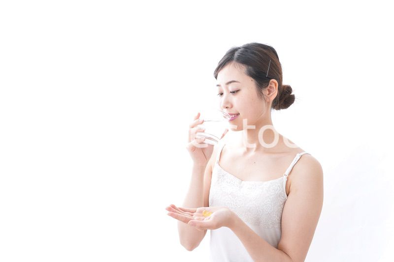 サプリメント・薬を飲む女性
