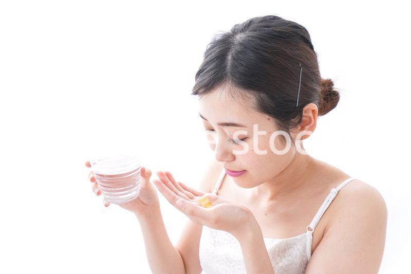 サプリメント・薬を飲む女性