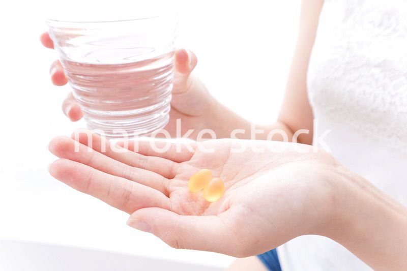 サプリメント・薬を飲む女性