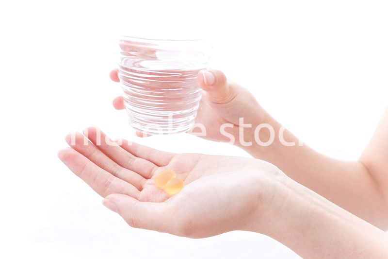 サプリメント・薬を飲む女性