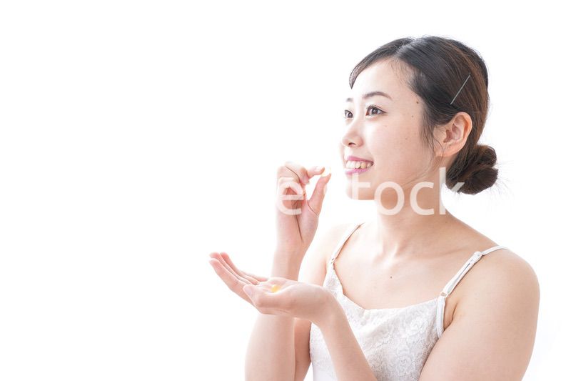 サプリメント・薬を飲む女性