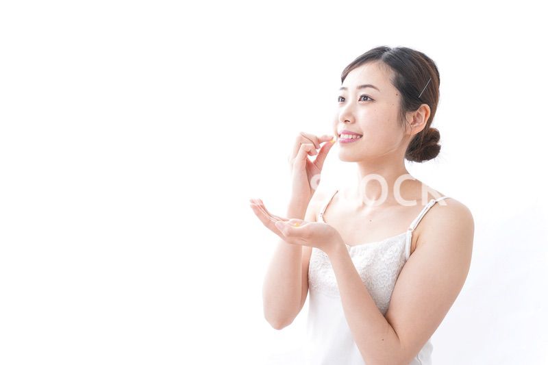 サプリメント・薬を飲む女性