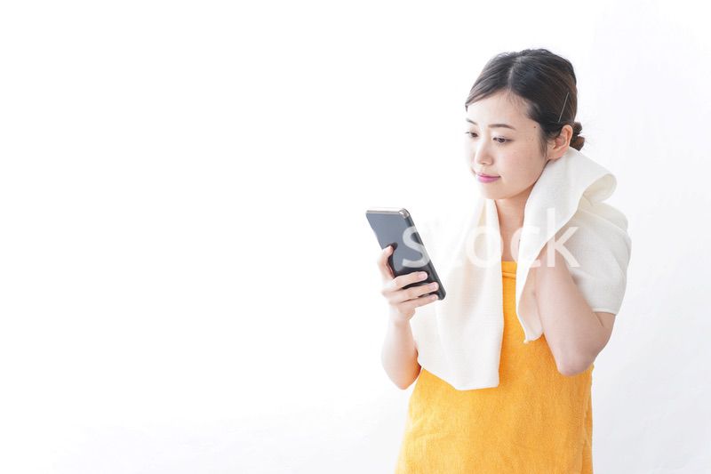 お風呂上がりにスマホをいじる女性