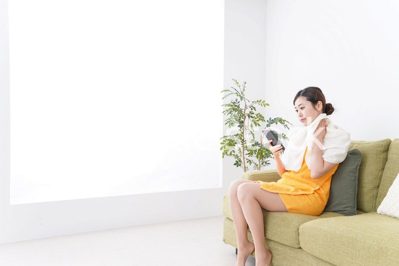 お風呂上がりにスマホをいじる女性
