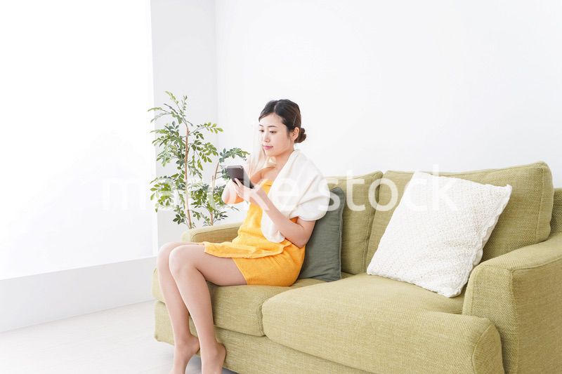 お風呂上がりにスマホをいじる女性