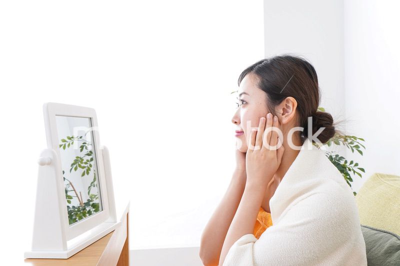 部屋でスキンケアをする若い女性