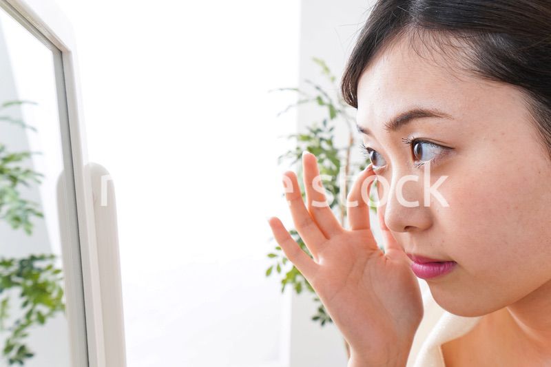 部屋でスキンケアをする若い女性