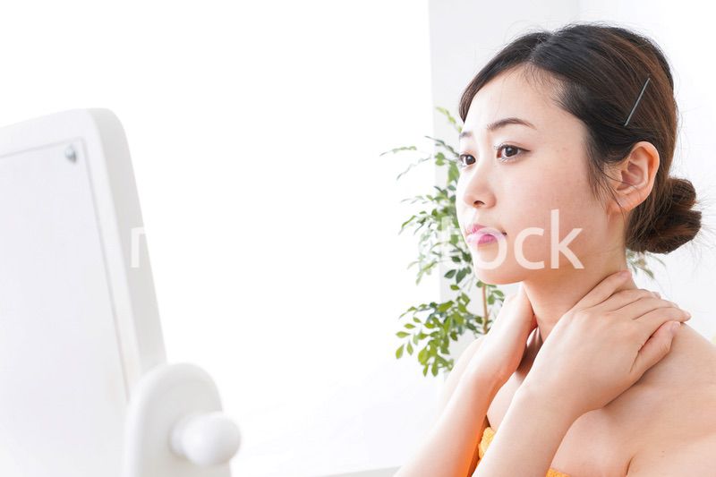 部屋でスキンケアをする若い女性