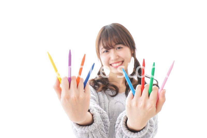 カラフルな色鉛筆を持つ女性