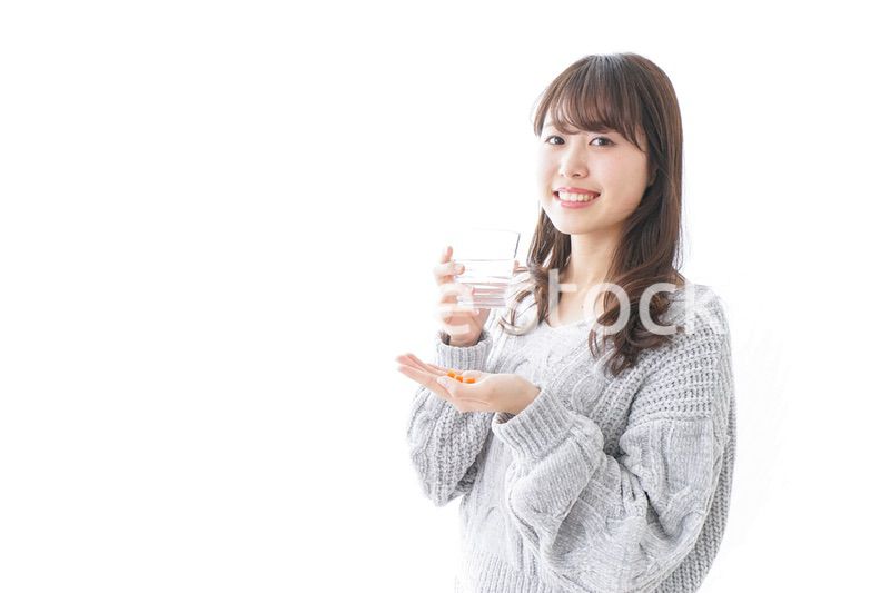 錠剤・サプリメントを飲む女性
