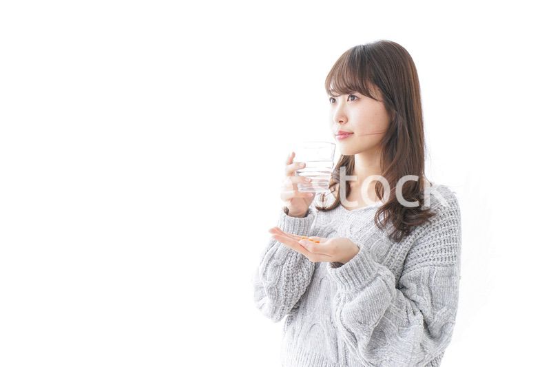 錠剤・サプリメントを飲む女性