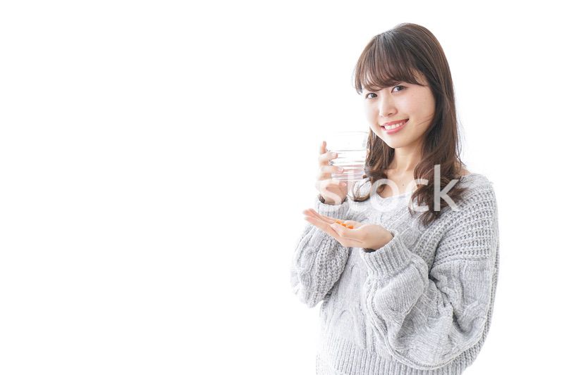 錠剤・サプリメントを飲む女性