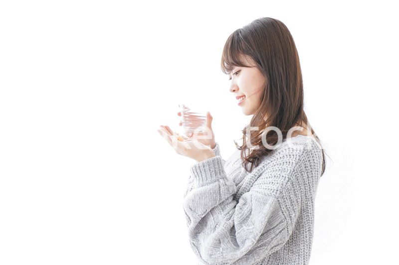 錠剤・サプリメントを飲む女性