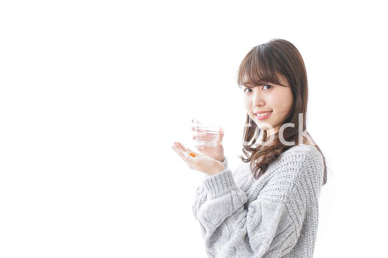 錠剤・サプリメントを飲む女性