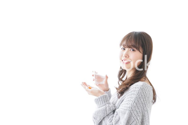 錠剤・サプリメントを飲む女性