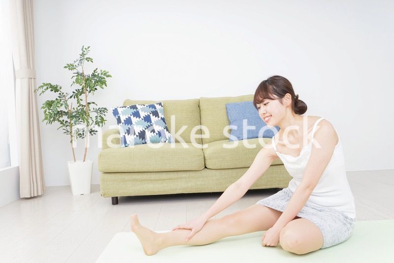 部屋でストレッチをする女性