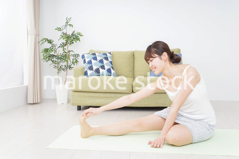 部屋でストレッチをする女性