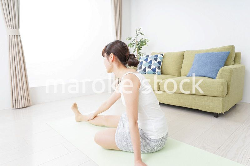 部屋でストレッチをする女性