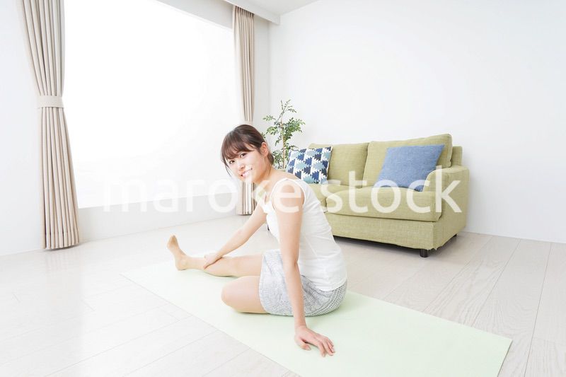 部屋でストレッチをする女性